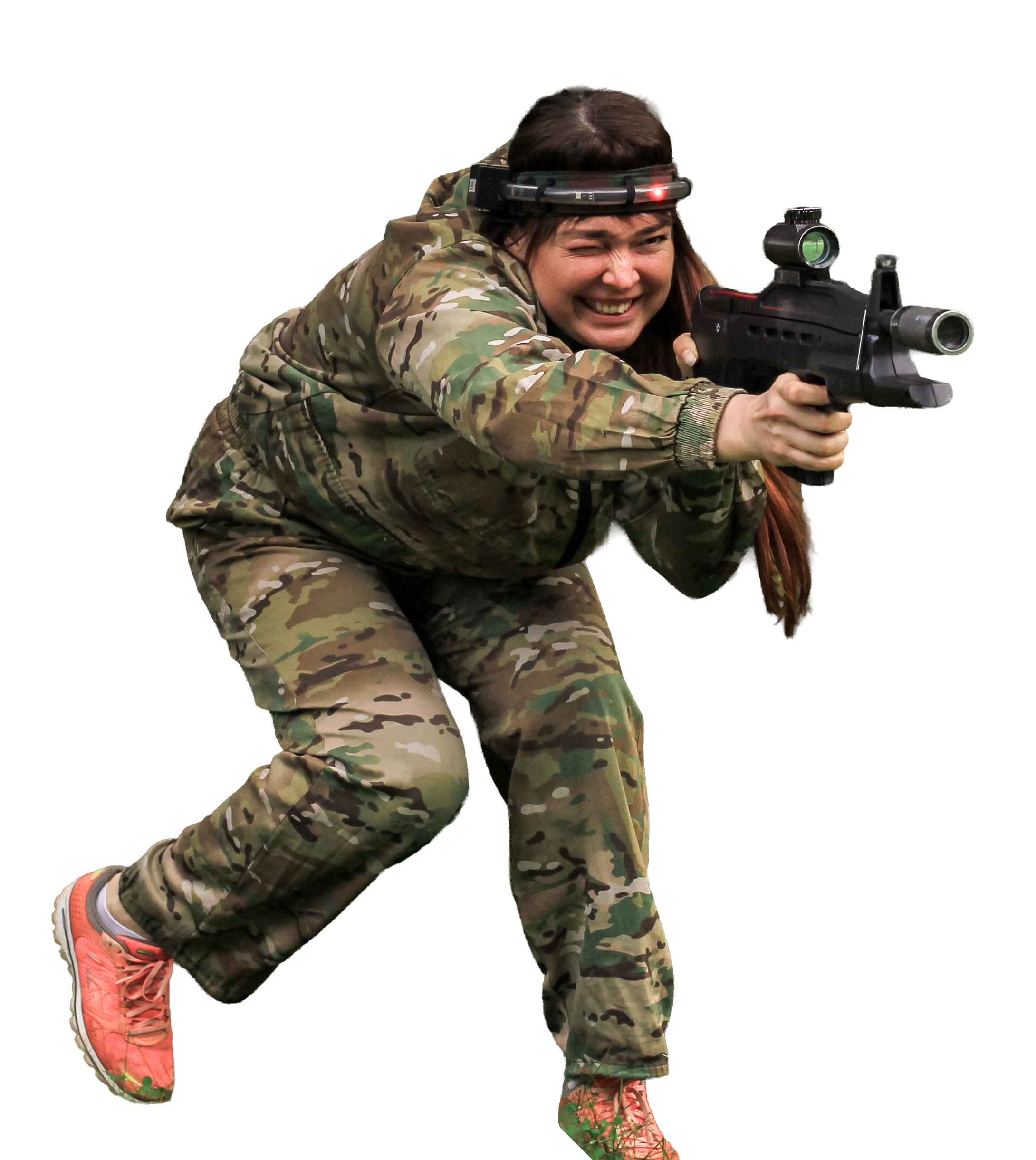 Donna in abbigliamento mimetico corre e mira con un fucile laser durante un’attività di outdoor laser game.